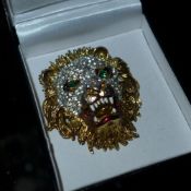 An ornate brooch in the form of a lion's head