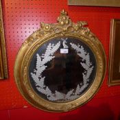 A C19th looking glass the circular plate with etched foliate and stag detail with carved giltwood