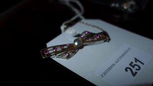 A yellow ladies brooch inset with central pearl and amythysts
