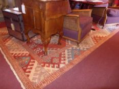 A hand knotted Kazak carpet with red field and repeating motifs in multi border