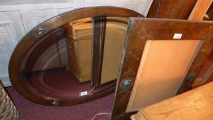 An Arts & Crafts looking glass the oval bevelled plated within planished copper frame