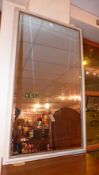 A wall mirror in grey painted frame with beaded detail