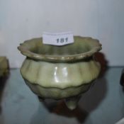 A Chinese Celadon glazed incense burner raised on three supports