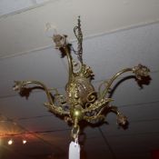 A C19th brass chandelier of five branches with leafy decoration and having cut glass sphere
