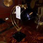A pair of ebonised and brass crescent desk lamps