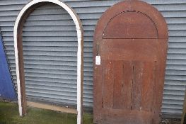 A wooden arched door and door frame