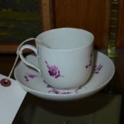 A C19th Meissen porcelain cup and saucer with purple flower spray decoration