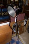 A chromium studio lamp on tripod base