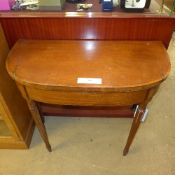 An Art Deco walnut demi-lune tea table raised on shaped supports