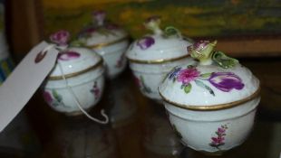 A Meissen set of four porcelain cups and cover with hand painted floral decoration (a/f)