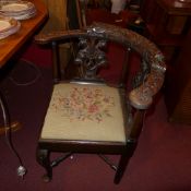 A C19th carved oak corner chair with tap