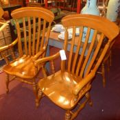 A set of four honey oak dining chairs in