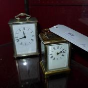 A brass carriage clock and a similar car