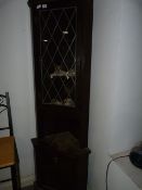 Dark Wood Corner Display Cabinet with Leaded Glass Door Containing Decorative Dolls