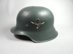 A German M1942 Luftwaffe helmet with leather lining and chin strap and painted eagle insignia