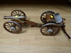 A miniature brass replica cannon of 12-pounder Napoleonic cannon with oak wooden carriage