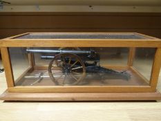 A gun-metal quality presentation miniature WWI artillery cannon in glass and wooden case