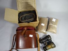 A leather cased set of binoculars together with two War Department shell dressings dated 1940 and