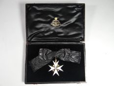 An Order of St John breast badge on ladies bow in silver and enamel in fitted velvet-lined case of