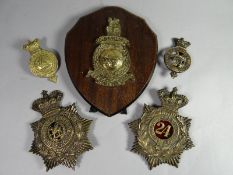 Two helmet plates and two badges relating to 24 Foot/South Wales Borderers, together with a Royal