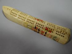 A scrimhaw cribbage counter with painted native patterning and moving peg base, 6 ins (15 cms) long
