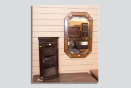 A quaint glass fronted mahogany corner cabinet with brass 'H' hinges and an oak framed bevelled edge