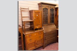 An oak bureau bookcase with stained glass top, twin leaded glazed doors over a cleated fall front