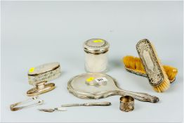 A parcel of non-matching silver dressing table items including two brushes, a hand mirror, two