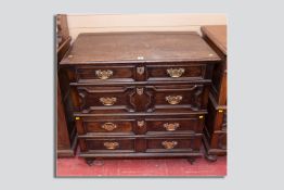 A late Victorian two part oak chest of drawers in the Jacobean style, moulded top over a flight of