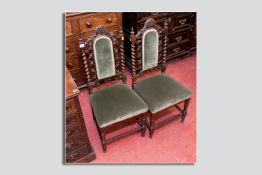 A pair of oak hall chairs with upholstered back panels and seats, pierced carving to the back