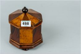 An early Victorian hexagonal shaped tea caddy having walnut and mahogany alternate segmented panels,