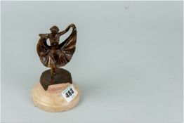 A metallic hinged skirt female figurine, 4.5 ins (11 cms) high on a circular pink marble base, 1.5