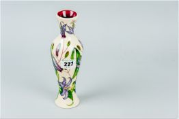 A slender Moorcroft cream ground vase having a raised orchid pattern, 8 ins (20.25 cms)