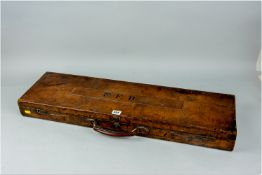 An oak carcassed and leather bound gun case with brass locks and feet having a raised central