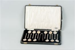 A cased set of twelve silver spade handled coffee spoons with matching tongs, 4.4 ozs, Birmingham