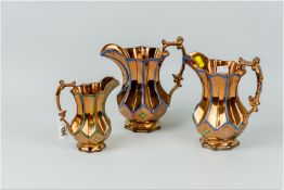 Three Victorian graduated copper lustre jugs of segmented form with a simple blue or green