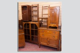 An oak tallboy, a walnut two door china display cabinet, two oak bedside cupboards, a small four