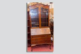 A mahogany fall front bureau bookcase, the swept top over twin glazed doors, chamfered and beaded