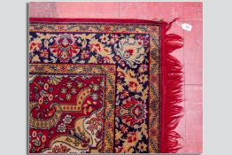 A red and gold patterned tassel edged carpet, 93 x 65 ins (236 x 165 cms)