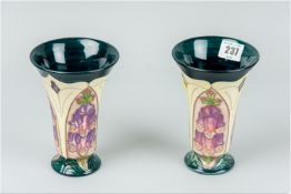 A pair of Moorcroft trumpet shaped vases, tube lined decorated in the 'Foxglove' pattern, deep
