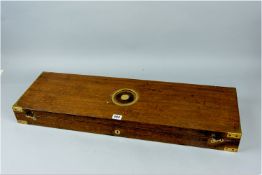 An oak and brass mounted gun case having a central brass bullseye with lift-up half ring carrying