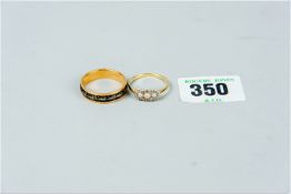 An eighteen carat gold wedding band with non-gold decoration, 4.9 grms and an eighteen carat gold