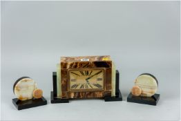 An onyx and marble eight day clock garniture set, the oblong dial clock having a French movement