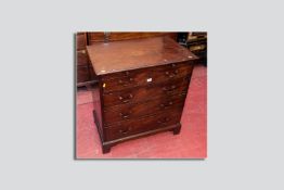 A Georgian mahogany bachelors chest of four drawers with cock beaded edge, brass swan neck handles