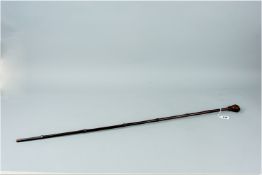 A bamboo sword stick with composite handle in the shape of a hand gripping a twisted form bar, 35
