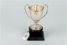A twin handled silver trophy cup on a black plinth, 2.4 ozs, Birmingham 1912