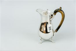 A plain silver hot milk jug with composition handle on three web supports, 8.5 ozs gross, Birmingham