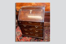 An 18th Century fall front bureau having a pierced brass galleried top, the fall opening to reveal a