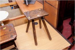 An early oak four legged milking stool, 15 x 10 ins (38 x 25.5 cms)