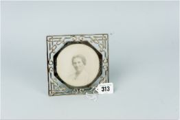 A square silver easel portrait frame, the frame in the form of Oriental style tubework and to take a